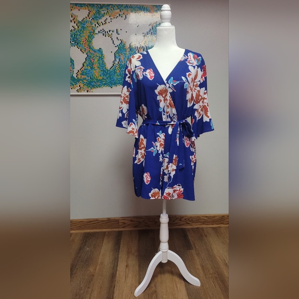 Short navy romper with white and red floral print.